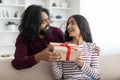 Loving young indian man giving present his surprised wife