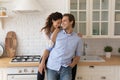 Loving young married couple cuddle at kitchen having fun together Royalty Free Stock Photo