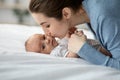 Loving Young Mom Kissing Her Cute Newborn Child While Relaxing In Bed Royalty Free Stock Photo