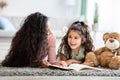 Loving young mother and her cute little daughter reading book at home Royalty Free Stock Photo