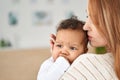 Loving young mother soothing cute infant baby girl teething biting hand. Royalty Free Stock Photo