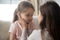 Loving young mother touching upset little daughter face, supporting Royalty Free Stock Photo