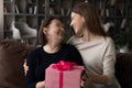 Loving young woman grown-up daughter congratulating mature mother, presenting gift Royalty Free Stock Photo