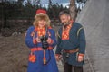 Sami man and woman, female saami, sami in national dress, saami village on the Kola Peninsula, Russia. They are looking at the