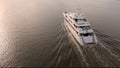 Low aerial view of large mega yacht crossing the ocean at sunrise