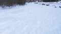 Low aerial view over the tracks left in the snow moving over the frozen river