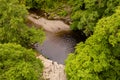 Low aerial view of a waterfall in a lush, green forest Sgwd Gwladys, Wales, UK