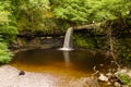 Low aerial view of a picturesque waterfall in a lush, green forest