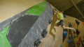 LOW ANGLE: Athletic climber jumps off a volume to reach up and grab another hold