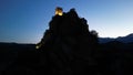 Low angle of the cliff that holds the medieval castle of Roccascalegna at night in southern Italy