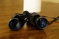 Low angle close up of black binoculars laying on a wood table Royalty Free Stock Photo
