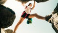 Low angle close up one young caucasian sporty woman alone train rock climb outdoors in sunny hot weather alone. Inspirational