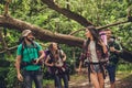 Low angle close up photo of four friends enjoying the beauty of nature, hiking in wild forest, looking for a nice place for camp,