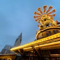 Low-angle closeup of the Christmas pyramid-like market at dawn in Germany cathedral background