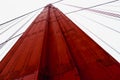 Low angle closeup detailed view of red Golden Gate Bridge tower and cables against the foggy sky, Royalty Free Stock Photo
