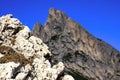 Low-angle closeup of rocky Grignetta mountain covered with green vegetation, blue sky background Royalty Free Stock Photo