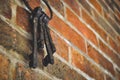 Low angle closeup of a set of vintage keys hanging from a brick wall Royalty Free Stock Photo