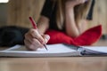 Low angle closeup view of female hand writing in spiral notebook Royalty Free Stock Photo