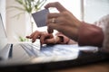 Low angle closeup view of female hands holding a credit card paying online