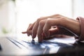 Low angle closeup view of female hands typing on laptop computer