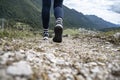 Low angle closeup view of female legs in hiking shoes walking on a trail