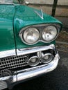 Low angle closeup view of the headlights of an old vintage green car Royalty Free Stock Photo