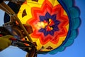 Low angle of a colorful hot air balloon and flames coming out of its burner against the blue sky Royalty Free Stock Photo