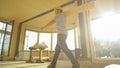 LOW ANGLE: Construction site supervisor carries a log across prefabricated house Royalty Free Stock Photo