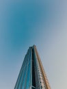 Low angle dramatic perspective of a sleek modern glass and steel skyscraper reaching into a clear blue sky Royalty Free Stock Photo
