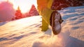 LOW ANGLE: Excited man on winter vacation runs into the glistening fresh snow.