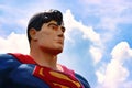 Low angle face shot of a metal statue of Superman. The facial expression is heroic and determined