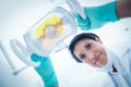 Low angle of female dentist adjusting light