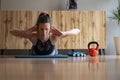 Low angle fron view of a young woman lying on a mat working out doing a back lift exercise