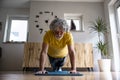 Low angle front view of a senior man living an active life working out at home