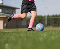 Low angle of girl kicking soccer ball