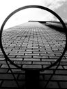 Low angle grayscale shot of a brick wall of a building against the cloudy sky