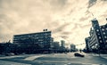 Low angle grayscale shot of a city crossroad surrounded with beautiful buildings