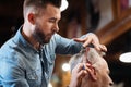 Low angle of handsome hairdresser doing his job