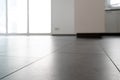 Low angle horizontal view of a new black ceramic tile floor in a bright white light apartment Royalty Free Stock Photo