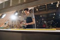 Low angle image of a craftsman grinding a wooden plank. In a big workshop. Royalty Free Stock Photo