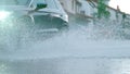 LOW ANGLE: Large car drives through the suburbs during a heavy spring rainstorm.