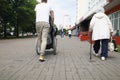 Man driving disabled woman in wheelchair across street, walking, shopping