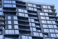 Low angle of modern facade of high rise building with glass exterior under blue sky in modern city district Royalty Free Stock Photo