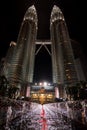 Low angle night time shot of the Petronas twin towers, Kuala Lumpur, Malaysia with red illuminated fountain in the foreground. Royalty Free Stock Photo