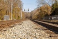 Low angle nostalgic image of two railroad tracks going into the woods.