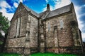 Low angle of an old stone church under a cloudy blue sky Royalty Free Stock Photo