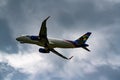 Low angle photo of a Spirit airplane in flight retracting landing gear position