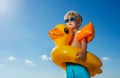 Low angle portrait of boy with inflatable yellow duck buoy Royalty Free Stock Photo