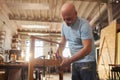 Low angle senior craftsman creating wooden furniture in carpentry workshop