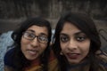 Portrait of two young Indian brunette girls/sisters/friends with traditional wear sari having fun on a rooftop Royalty Free Stock Photo